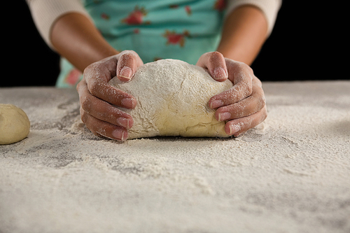 Mid-section of woman kneading a dough