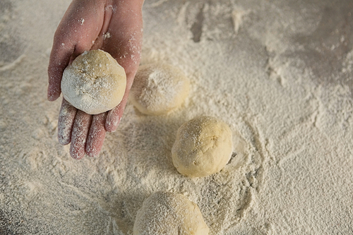 Close-up of hand holding a dough ball
