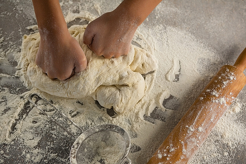 Close-up of woman kneading a dough