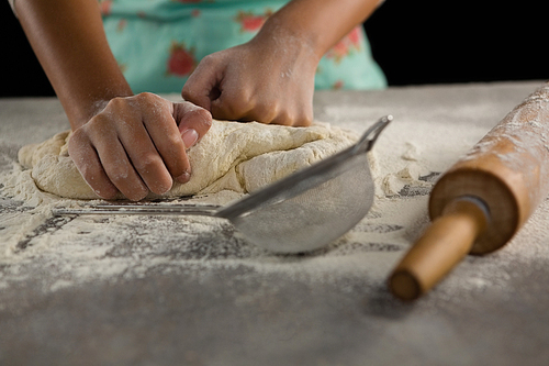 Mid-section of woman kneading a dough