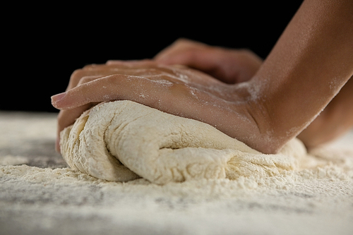 Close-up of woman kneading a dough