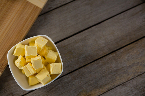 Overhead view of cheese cubes in a bowl on wooden table