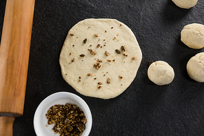 Over head view of dry fruits added over flattened dough