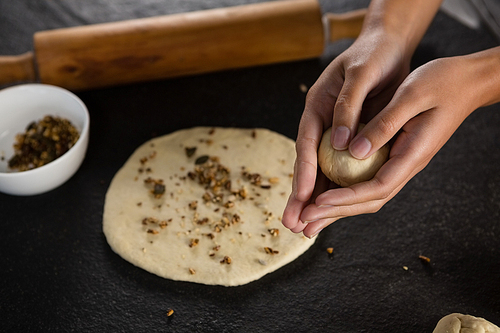 Close-up of woman rolling a dough ball in her hand