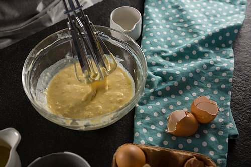 Close-up of freshly whisked batter of beaten eggs, milk and butter in a bowl