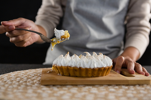 Mid section of woman picking up tart with a fork