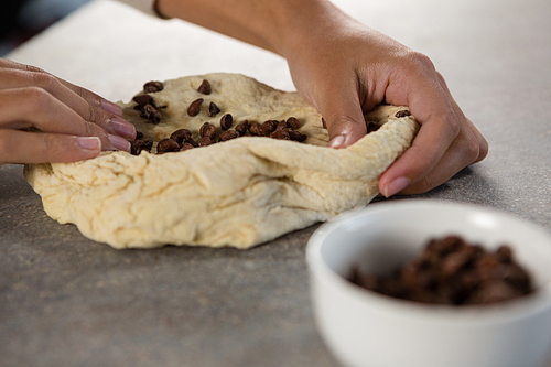 Close-up of woman kneading dough with chocolate chips