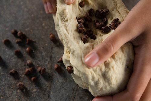 Close-up of woman kneading dough with chocolate chips