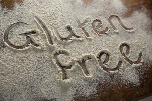 Close-up of the word gluten free written on sprinkled flour