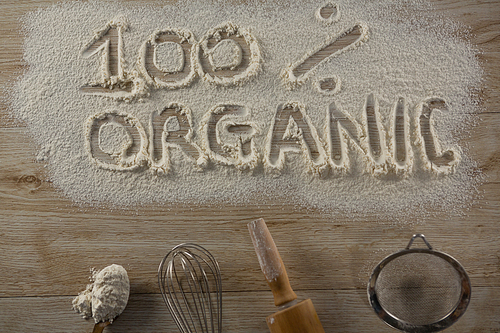 Over head view of the word 100 percent organic written on sprinkled flour
