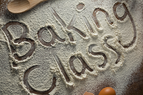 Close-up of the word baking class written on sprinkled flour