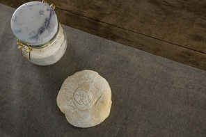 Close-up of dough ball pressed over butter paper