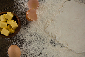 Close-up of flattened dough sprinkled with flour on a wooden table