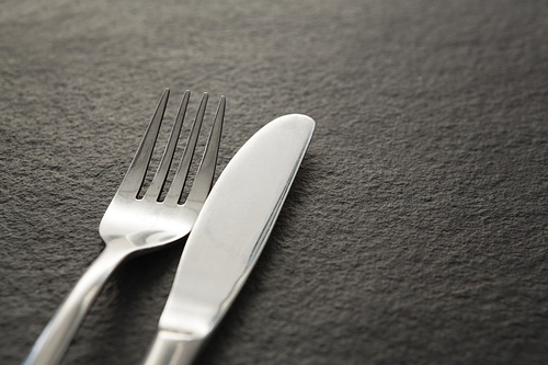 Close-up of fork and knife on black background