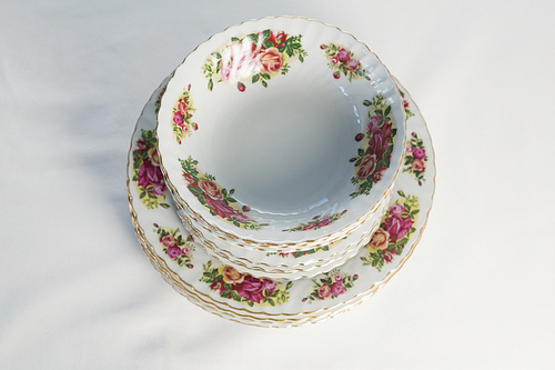 Close-up of plates and bowl with floral design set elegantly on a table