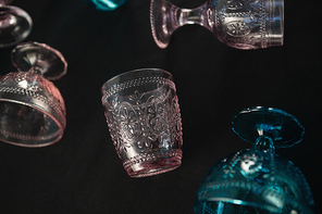 Close-up of colored glass and cups against a black background