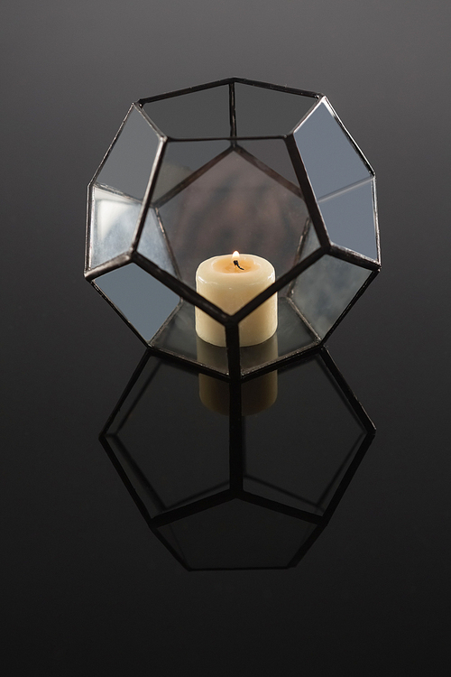 Close-up of lit candle on candle holder