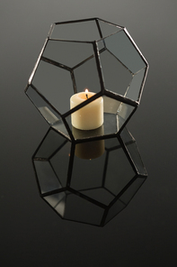 Close-up of lit candle on candle holder