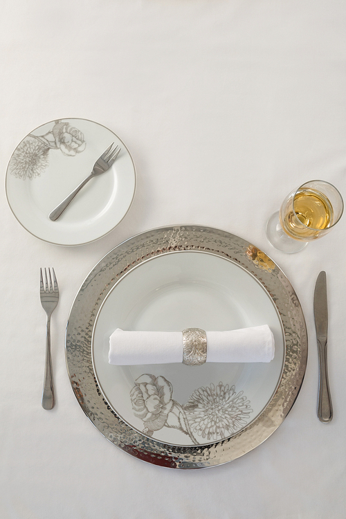 Overhead view of plate and cutlery set elegantly on a table