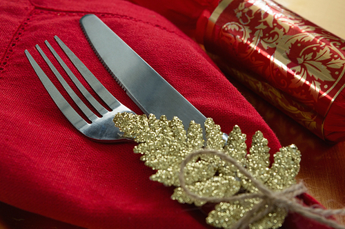 Close-up of chocolate and cutlery with napkin tied up with a rope