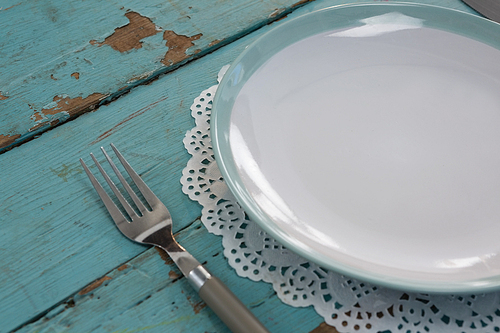 Close-up of plate with fork on wooden table