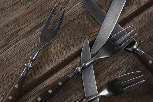 Overhead of various cutlery on wooden plank