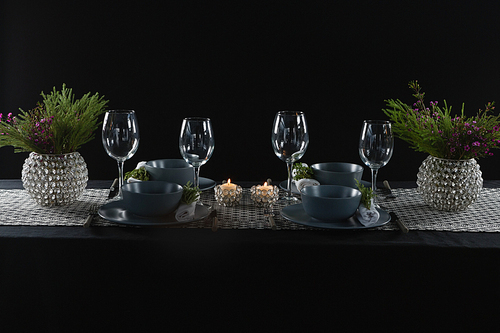 Elegance table setting with empty wine glasses and lit candle on table
