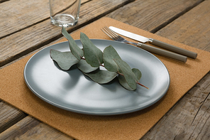 Elegant table setting with leaf and cutlery on table