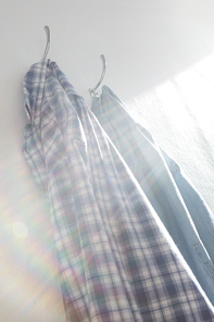 Close-up of shirts hanging on hook against wall
