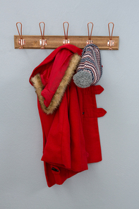 Warm clothing hanging on hook against wall