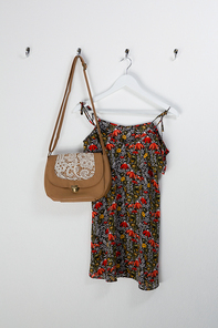 Dress and bag hanging on hook against wall