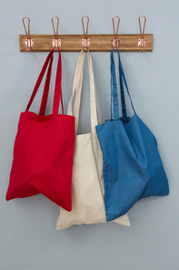 Close-up of various handbags hanging on hook