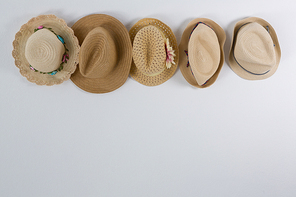 Various straw hats hanging on hook against wall