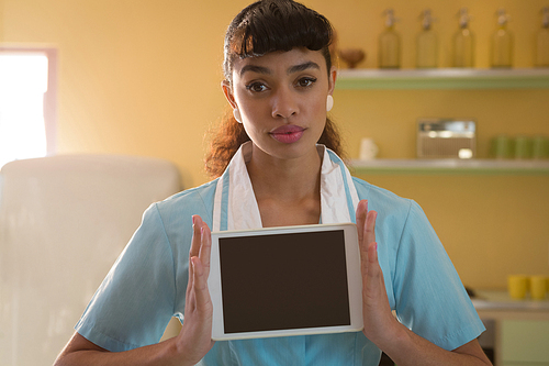 Portrait of waitress holding digital tablet in restaurant