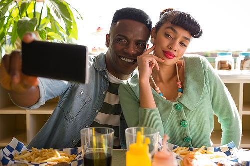 Couple taking selfie while having food in the restaurant