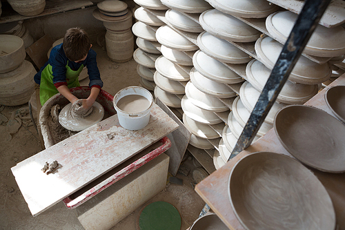 Boy making a pot in pottery workshop