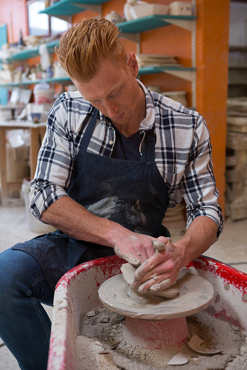 Male potter making a pot in pottery workshop