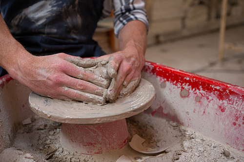 Male potters hand making a pot in pottery workshop