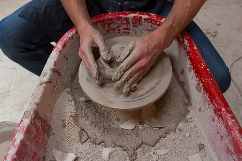 Male potters hand making a pot in pottery workshop