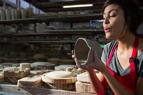 Female potter preparing mug in pottery workshop