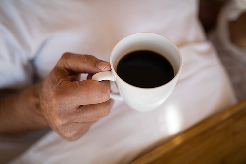 Mid section of man having black coffee during morning