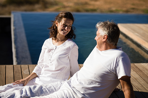 Happy couple relaxing on wooden plank on a sunny day