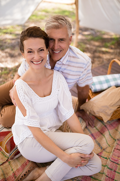 Portrait of happy couple sitting in cottage during safari vacation