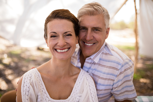 Portrait of happy couple sitting in cottage during safari vacation