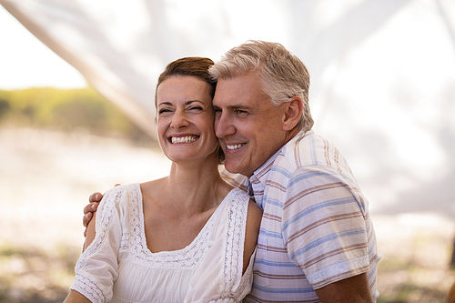 Happy couple sitting in cottage during safari vacation