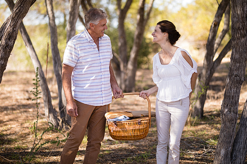 Smiling couple holding a wicker basket during safari vacation