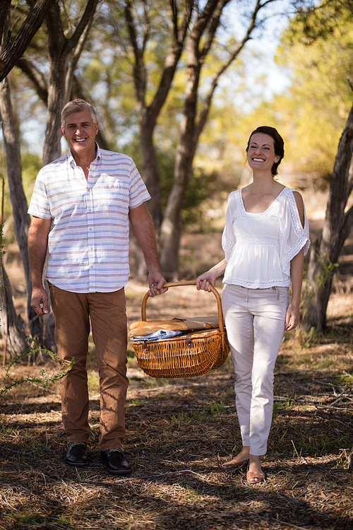 Portrait of smiling couple holding a wicker basket during safari vacation