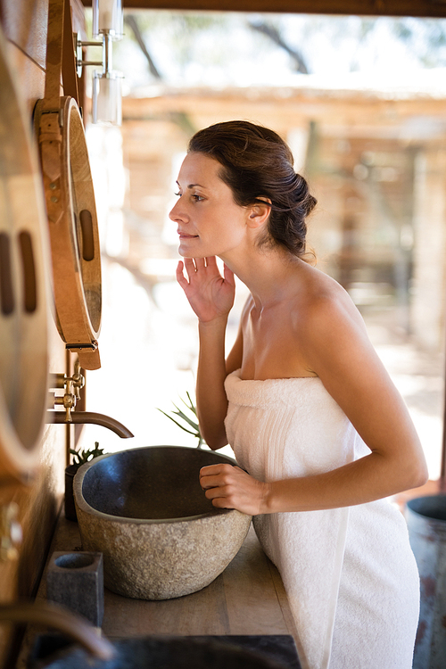 Woman looking at mirror in cottage during safari vacation