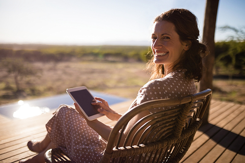 Portrait of senior woman using digital tablet while sitting