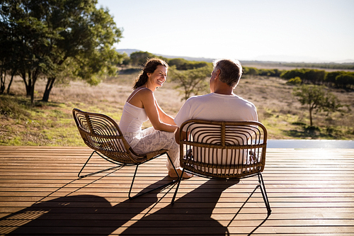 Senior couple sitting on chairs at the resort on a sunny day